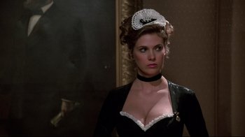 Movie still from “Clue” (1985), directed by Jonathan Lynn – A woman in a black dress and a white hat; Close Up shot, Low angle