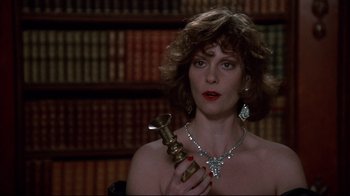 Movie still from “Clue” (1985), directed by Jonathan Lynn – A woman holding a trophy while wearing a necklace; Close Up shot, Low angle