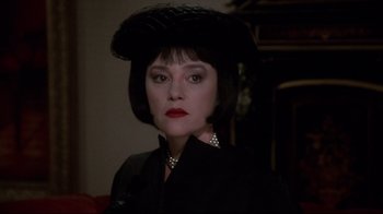Movie still from “Clue” (1985), directed by Jonathan Lynn – A person wearing a hat; Close Up shot, Over the shoulder angle