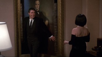 Movie still from “Clue” (1985), directed by Jonathan Lynn – A man and a woman in a black dress; Medium shot, Over the shoulder angle