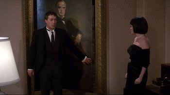Movie still from “Clue” (1985), directed by Jonathan Lynn – A man and a woman standing in front of a painting; Medium shot, Over the shoulder angle