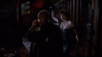 Movie still from “Clue” (1985), directed by Jonathan Lynn – A man and a woman are standing next to each other; Medium shot, Over the shoulder angle