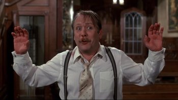 Movie still from “Clue” (1985), directed by Jonathan Lynn – A man in a white dress shirt and a tie; Close Up shot, Low angle