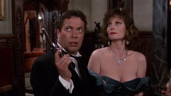 Movie still from “Clue” (1985), directed by Jonathan Lynn – A man and a woman holding a gun in front of a mirror; Close Up shot, Low angle