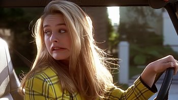 Movie still from “Clueless” (1995), directed by Amy Heckerling – A woman with long blonde hair wearing a yellow shirt; Close Up shot, Over the shoulder angle