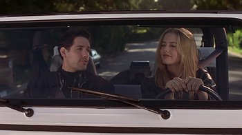 Movie still from “Clueless” (1995), directed by Amy Heckerling – A man and a woman sitting in the back of a car; Medium shot, Low angle