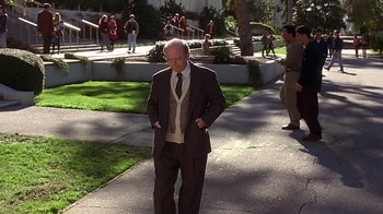 Movie still from “Clueless” (1995), directed by Amy Heckerling – An older man in a suit and tie standing on a sidewalk; Wide shot, High angle