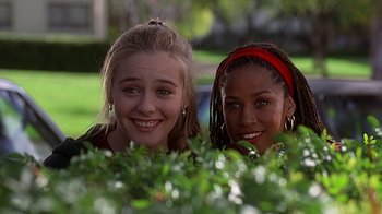 Movie still from “Clueless” (1995), directed by Amy Heckerling – Two young women are posing for a picture; Medium shot, Low angle