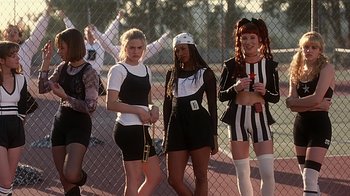 Movie still from “Clueless” (1995), directed by Amy Heckerling – A group of women standing next to each other on a tennis court; Medium shot, Low angle