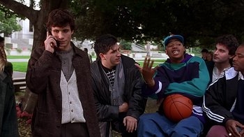 Movie still from “Clueless” (1995), directed by Amy Heckerling – A group of young men standing next to each other in a park; Medium shot, Low angle