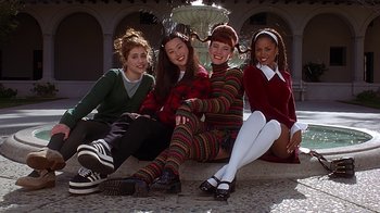 Movie still from “Clueless” (1995), directed by Amy Heckerling – A group of young women sitting next to each other on the ground; Medium shot, Low angle
