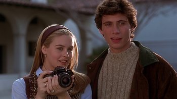 Movie still from “Clueless” (1995), directed by Amy Heckerling – A man and a woman are holding a camera; Close Up shot, Over the shoulder angle