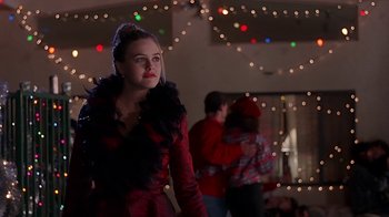 Movie still from “Clueless” (1995), directed by Amy Heckerling – A woman in a red and black outfit standing in front of a christmas tree; Medium shot, Over the shoulder angle