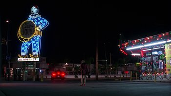 Movie still from “Clueless” (1995), directed by Amy Heckerling – A woman standing in the middle of an empty parking lot at night; Extreme Wide shot, Low angle