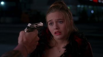 Movie still from “Clueless” (1995), directed by Amy Heckerling – A woman holding a gun up to her face; Close Up shot, Over the shoulder angle