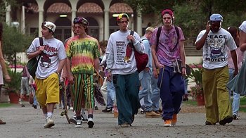 Movie still from “Clueless” (1995), directed by Amy Heckerling – A group of young men walking down a street; Wide shot, Low angle