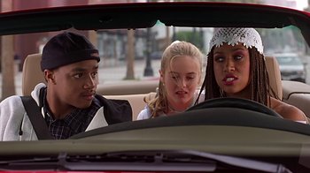 Movie still from “Clueless” (1995), directed by Amy Heckerling – A group of people sitting in the back of a car; Medium shot, Over the shoulder angle