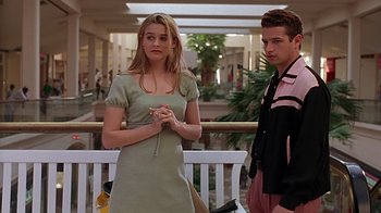Movie still from “Clueless” (1995), directed by Amy Heckerling – A woman standing next to a young man in a mall; Medium shot, Over the shoulder angle