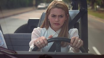 Movie still from “Clueless” (1995), directed by Amy Heckerling – A woman driving a car in the middle of the road; Close Up shot, Over the shoulder angle