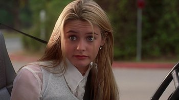 Movie still from “Clueless” (1995), directed by Amy Heckerling – A woman with long blonde hair wearing a white shirt; Close Up shot, Low angle