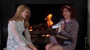 Movie still from “Clueless” (1995), directed by Amy Heckerling – Two young women sitting in front of a fireplace; Medium shot, High angle