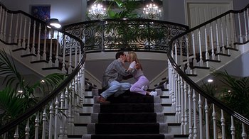 Movie still from “Clueless” (1995), directed by Amy Heckerling – A man and a woman sitting on the bottom of a staircase; Wide shot, Low angle