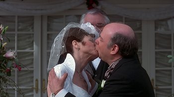 Movie still from “Clueless” (1995), directed by Amy Heckerling – A man and a woman kissing each other on the cheek; Close Up shot, Low angle
