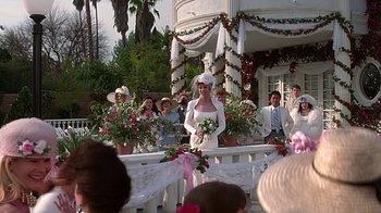 Movie still from “Clueless” (1995), directed by Amy Heckerling – A woman in a white dress standing in front of a group of people; Wide shot, Over the shoulder angle