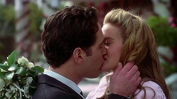 Movie still from “Clueless” (1995), directed by Amy Heckerling – A man and a woman kissing each other in front of flowers; Close Up shot, Low angle