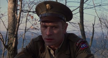 Movie still from “Coal Miner's Daughter” (1980), directed by Michael Apted – A man in a military uniform is sitting in front of a tree; Close Up shot, Over the shoulder angle