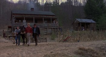 Movie still from “Coal Miner's Daughter” (1980), directed by Michael Apted – Two men are walking in front of a log cabin; Wide shot, Low angle