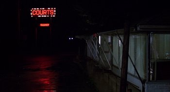 Movie still from “Coal Miner's Daughter” (1980), directed by Michael Apted – A sign that reads " courts " on a rainy night; Extreme Wide shot, Low angle
