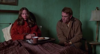 Movie still from “Coal Miner's Daughter” (1980), directed by Michael Apted – A man and a woman sitting next to each other at a table; Medium shot, Over the shoulder angle