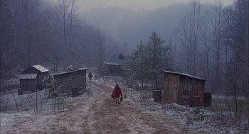 Movie still from “Coal Miner's Daughter” (1980), directed by Michael Apted – A man in a red coat sitting on the side of a dirt road; Extreme Wide shot, High angle