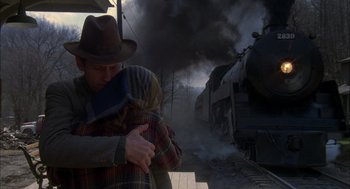 Movie still from “Coal Miner's Daughter” (1980), directed by Michael Apted – A man and a woman hug in front of a train on the tracks; Medium shot, Low angle