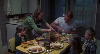 Movie still from “Coal Miner's Daughter” (1980), directed by Michael Apted – A group of people sitting at a table with plates of food on it; Medium shot, High angle