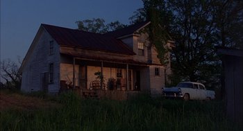 Movie still from “Coal Miner's Daughter” (1980), directed by Michael Apted – An old house with a car parked in front of it; Extreme Wide shot, Low angle