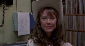 Movie still from “Coal Miner's Daughter” (1980), directed by Michael Apted – A woman wearing a white cowboy hat and a floral shirt; Close Up shot, Over the shoulder angle