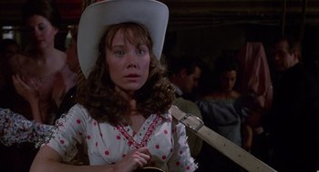Movie still from “Coal Miner's Daughter” (1980), directed by Michael Apted – A woman in a cowboy hat holding a guitar in front of a crowd; Close Up shot, Over the shoulder angle