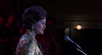 Movie still from “Coal Miner's Daughter” (1980), directed by Michael Apted – A woman in a sequined jacket singing into a microphone; Close Up shot, Over the shoulder angle
