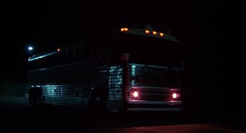 Movie still from “Coal Miner's Daughter” (1980), directed by Michael Apted – A bus is driving down the street at night; Wide shot, Low angle