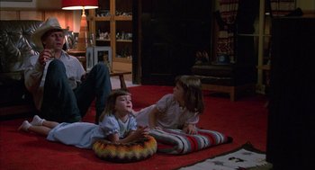 Movie still from “Coal Miner's Daughter” (1980), directed by Michael Apted – Two young girls sitting on the ground in a living room; Wide shot, High angle
