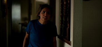 Movie still from “Coast” (2021), directed by Derek Schweickart – A woman standing in front of a window; Medium shot, Over the shoulder angle