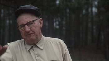 Movie still from “Cockfighter” (1974), directed by Monte Hellman – An older man wearing glasses and a hat; Close Up shot, Over the shoulder angle