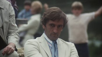 Movie still from “Cockfighter” (1974), directed by Monte Hellman – A man in a white suit and a blue tie; Close Up shot, Low angle
