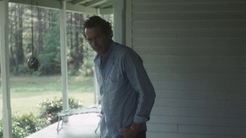 Movie still from “Cockfighter” (1974), directed by Monte Hellman – A man standing in front of a window; Medium shot, Low angle