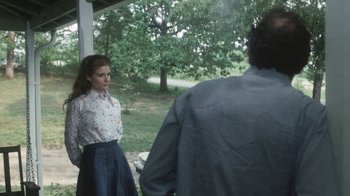 Movie still from “Cockfighter” (1974), directed by Monte Hellman – A woman standing next to a man on a porch; Medium shot, Over the shoulder angle