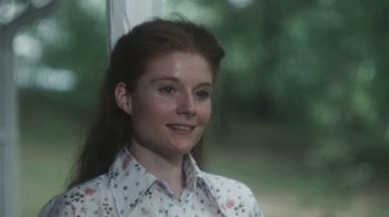 Movie still from “Cockfighter” (1974), directed by Monte Hellman – A woman with long red hair wearing a floral shirt; Close Up shot, Over the shoulder angle