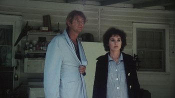 Movie still from “Cockfighter” (1974), directed by Monte Hellman – A man and a woman standing next to each other in front of a refrigerator; Medium shot, Low angle