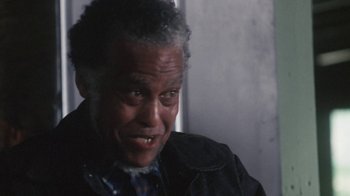 Movie still from “Cockfighter” (1974), directed by Monte Hellman – An older man is smiling for the camera; Close Up shot, Low angle